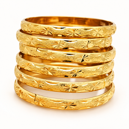 Six matching 18K gold-plated engraved starburst bangles on a white background